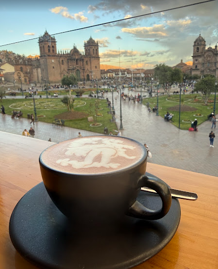 imagem de uma xícara de café com a catedral de cusco e a praça de armas ao fundo.