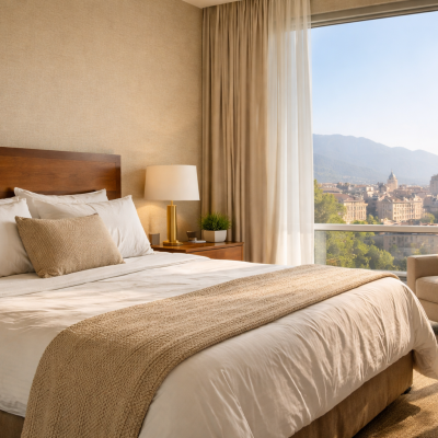 quarto de hotel confortável com cama grande e vista para a cidade iluminado por luz natural